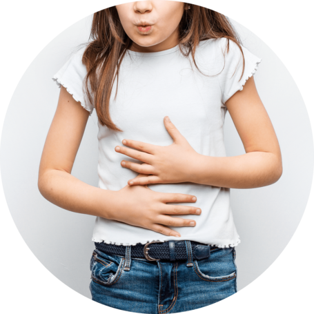 Young girl holding her stomach, indicating discomfort, wearing a white t-shirt and blue jeans